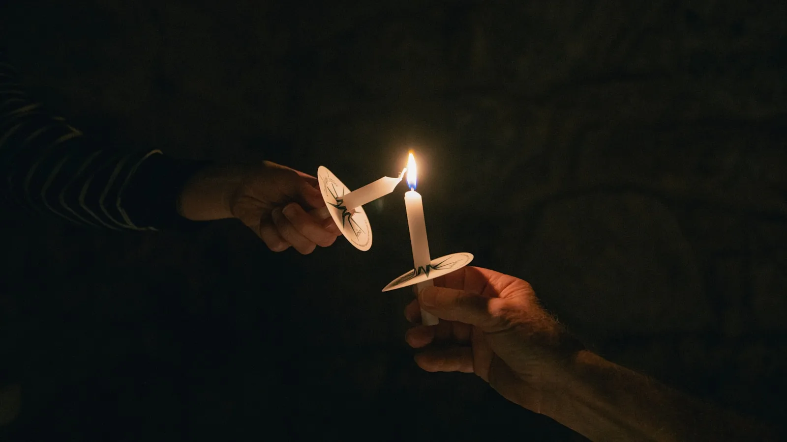 Photo by Zach Lucero two people holding a candle in their hands